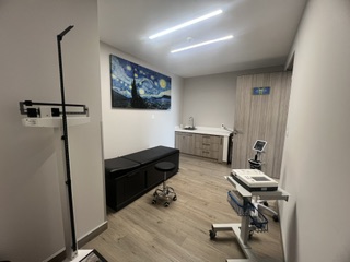 Physical examination room equipped with a calibrated 12-lead ECG, scale, and sphygmomanometer.